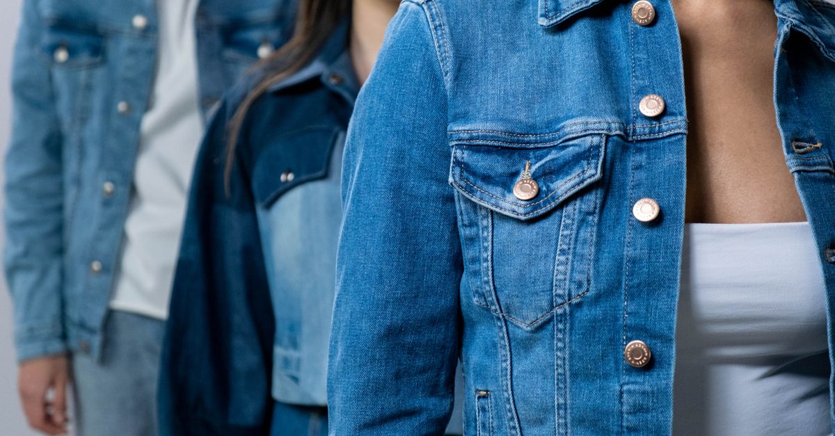 Group of people modeling stylish denim jackets in studio setting.