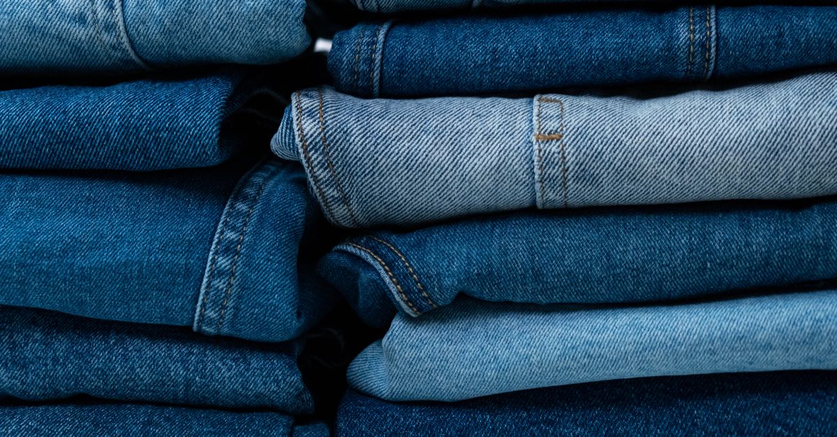 Close-up of stacked blue denim jeans showcasing different textures and shades.